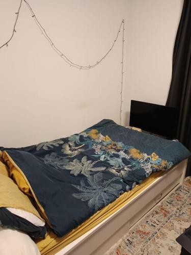 Una cama con una manta azul encima. en La Maison Bleue - La Haye, en La Haya