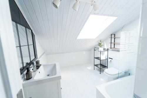 a white bathroom with a sink and a toilet at Vila Sen Vento - Aguiño in Ribeira