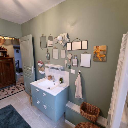 une salle de bain avec un lavabo et un miroir dans l'établissement La Damoiselle en Bourgogne, à Ouanne