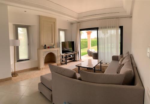 a living room with a couch and a fireplace at LUXUEUSE VILLA AVEC PISCINE PRIVEE PROCHE D'AGADIR in Agadir