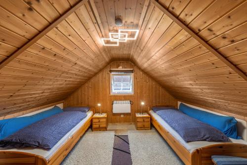 two beds in a room with a wooden ceiling at Ferienhaus Sonnenblumen in Boltenhagen