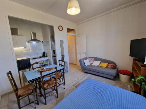 uma sala de estar com uma mesa e um sofá em Apartment close to Lyon and Parc de Parilly em Saint-Priest