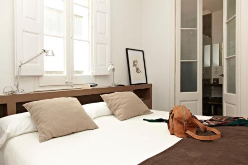 バルセロナにあるMosaic Elegant Apartmentの白いベッド(上に袋付)