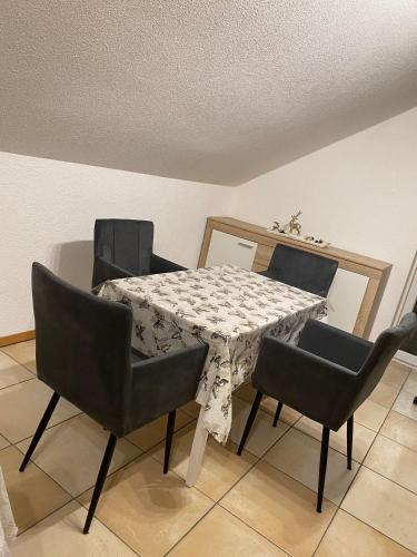 a dining room with a table and four chairs at Haus Stegmeir in Hohenweiler