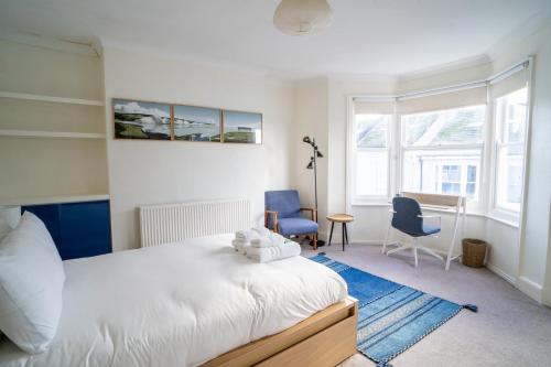 een slaapkamer met een bed en 2 stoelen en een bureau bij GuestReady - Kemptown Coastal Comfort in Brighton & Hove