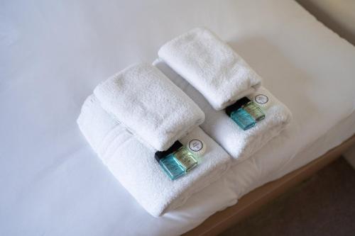 two towels on top of a white bed at GuestReady - Kemptown Coastal Comfort in Brighton & Hove