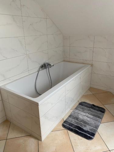 a white bath tub in a bathroom with a rug at Haus Stegmeir in Hohenweiler