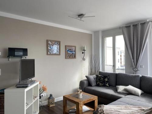 ein Wohnzimmer mit einem Sofa und einem TV in der Unterkunft Villa Seeadler in Börgerende-Rethwisch