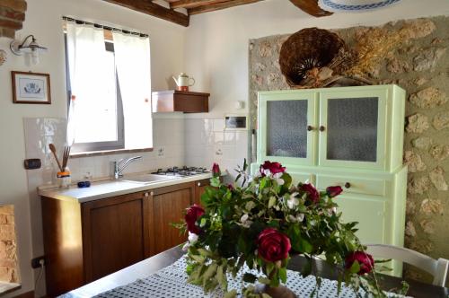 kuchnia ze stołem z wazą róż w obiekcie Agriturismo Il Caggio w mieście Sovicille