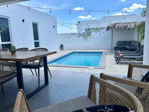 a patio with a table and a swimming pool at Villa Sol A Luna - Mambo Beach in Willemstad