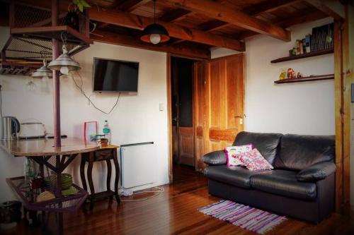 Una sala de estar con un sofá de cuero y una mesa. en Loft Antiguo sobre Av de Mayo, en Buenos Aires