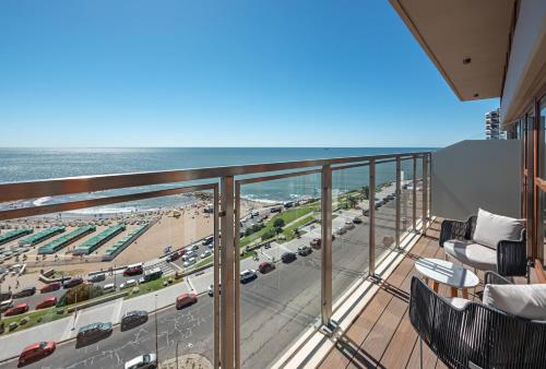 a balcony with a view of a beach and the ocean at HOTEL KONKE MAR DEL PLATA in Mar del Plata
