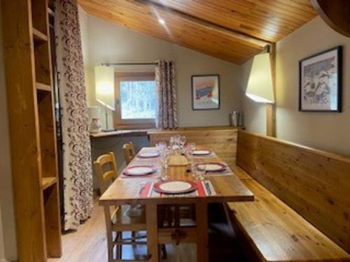 une salle à manger avec une table en bois dans une maison dans l'établissement Appartement spacieux proche centre village avec balcon et vue Mont Blanc - FR-1-181-2479, à La Plagne Tarentaise