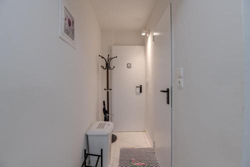 La salle de bains blanche est pourvue d'une douche et de toilettes. dans l'établissement Paleo Faliro Gardenbay, à Athènes