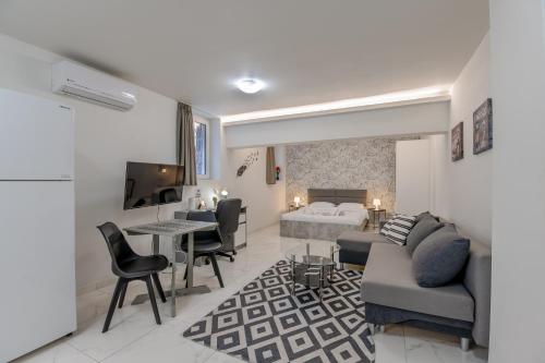 a living room with a couch and a bed at Paleo Faliro Gardenbay in Athens