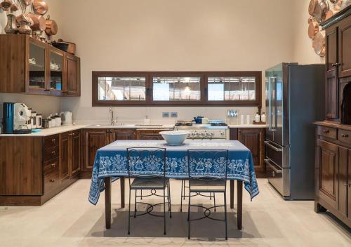 a kitchen with a table with a blue table cloth on it at Casale Gambini in Quattro Castella