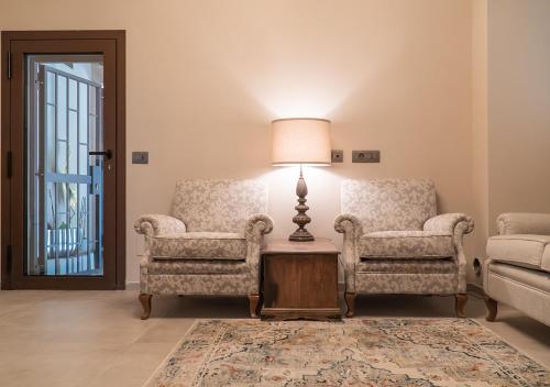 a living room with two chairs and a lamp at Casale Gambini in Quattro Castella