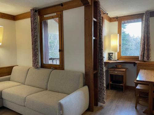 un salon avec un canapé et deux fenêtres dans l'établissement Studio cosy à deux pas des pistes avec balcon et casier à skis - FR-1-181-2482, à La Plagne Tarentaise
