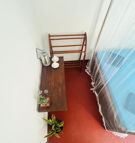 a balcony with a wooden table and a bed at Moon Bay in Mirissa
