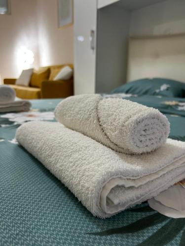uma pilha de toalhas sentadas em cima de uma cama em Sindi's Daily Apartment em Durrës