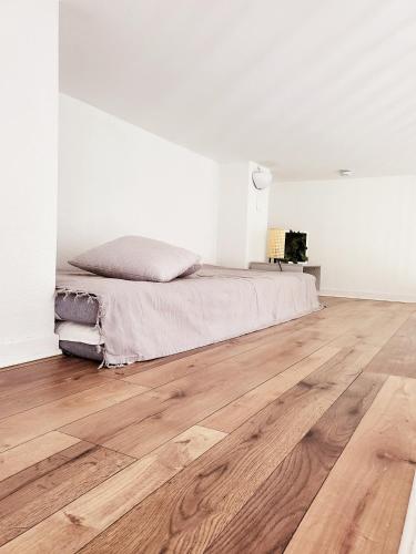 une chambre avec un lit et un parquet dans l'établissement La Suite Costabella à Hyères-les-Palmiers, à Hyères