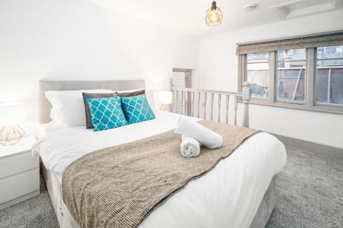 a bedroom with a large white bed with blue pillows at Wolverhampton 1 Bed Apartment - Top Rated -Netflix - Wifi - 12AC in Wolverhampton