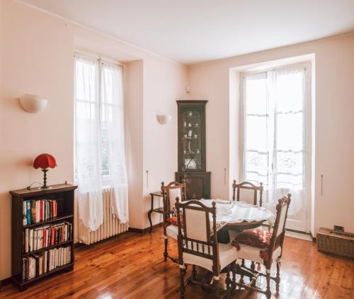 comedor con mesa, sillas y ventanas en Authentic Italian Home, en Cadenabbia