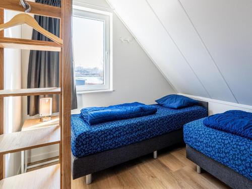 een slaapkamer met 2 bedden en een ladder bij Nice holiday home in Simonshaven with garden in Simonshaven