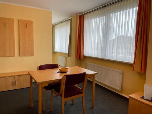a conference room with a table and chairs and windows at Pension Leyerhof in Wendisch Baggendorf