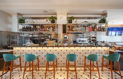 a bar with green chairs in a restaurant at HOTEL KONKE MAR DEL PLATA in Mar del Plata