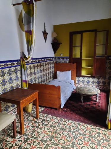 a bedroom with a bed and a table at Dar Halima in Essaouira