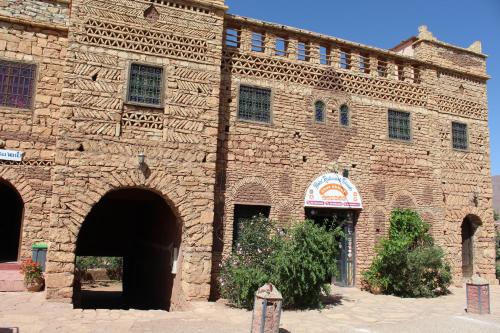 a large brick building with two arched entrances at Auberge Restaurant Telouet in Telouet