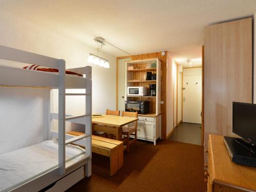 Cette petite chambre comprend des lits superposés et une table. dans l'établissement Studio confortable au cœur de Montchavin avec casier à skis et accès télécabine - FR-1-181-2551, à La Plagne Tarentaise