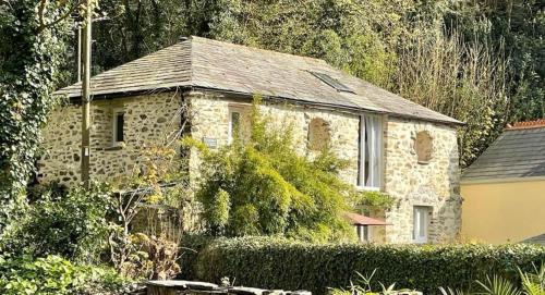 an old stone house in the middle of a yard at Chapel Barn in Bodmin