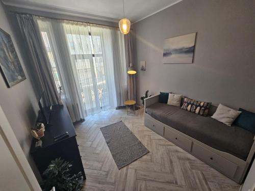 a living room with a couch and a large window at ZIG ZAG apartment 4- Old Town in Constanţa