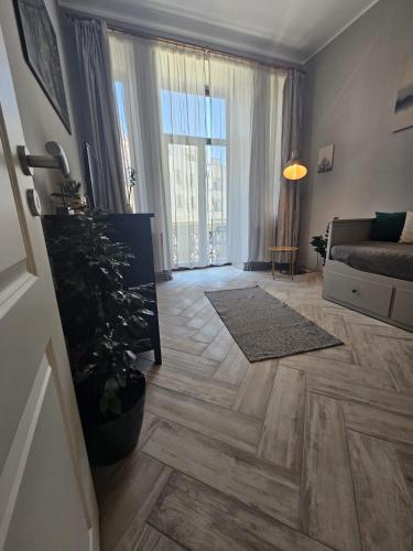 a living room with a couch and a tree at ZIG ZAG apartment 4- Old Town in Constanţa