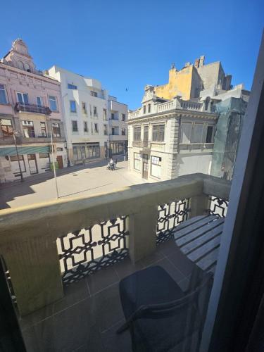 a balcony with a chair and buildings on a street at ZIG ZAG apartment 4- Old Town in Constanţa