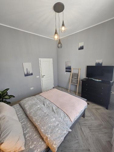 a bedroom with a bed and a dresser and lights at ZIG ZAG apartment 4- Old Town in Constanţa