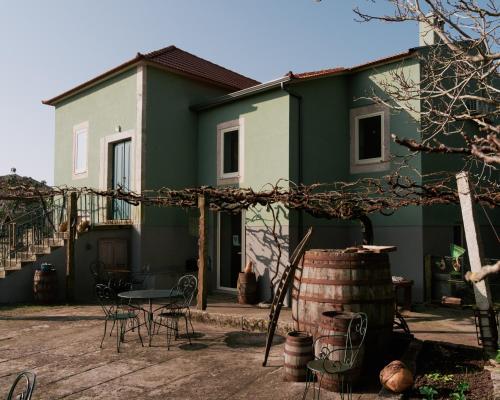 a green and white house with a table and chairs at Quinta da Quinhas in Vila Praia de Âncora