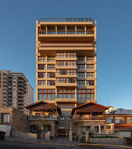 a tall building in front of some buildings at HOTEL KONKE MAR DEL PLATA in Mar del Plata