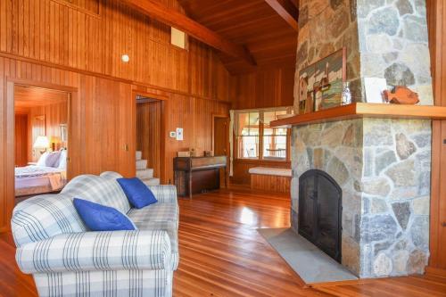 sala de estar con chimenea de piedra y sofá en Steps to Nauset Beach Private Yard, en Orleans