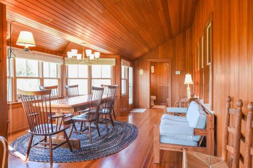 a dining room with a table and chairs and a couch at Steps to Nauset Beach Private Yard in Orleans