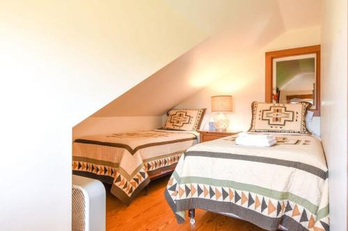 a attic bedroom with two beds and a mirror at Steps to Nauset Beach Private Yard in Orleans