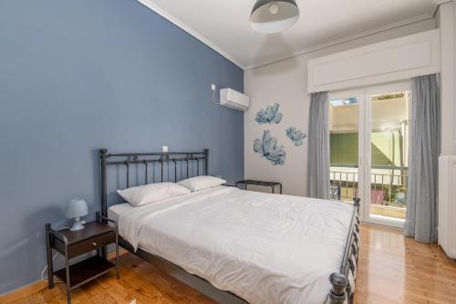 a bedroom with a large bed with blue walls at Marina Zeas Livemodern in Piraeus
