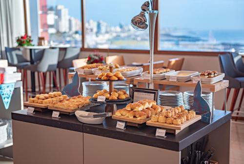 a buffet of pastries and breads on a table at HOTEL KONKE MAR DEL PLATA in Mar del Plata
