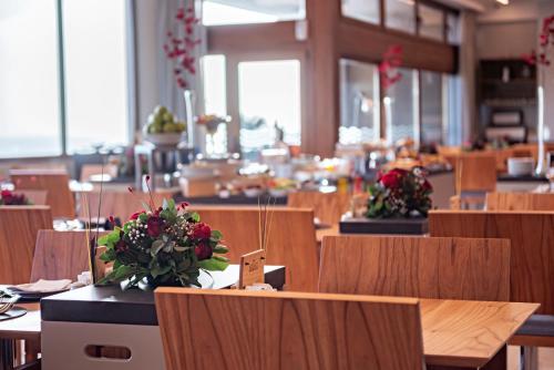 a restaurant with tables and chairs with flowers on them at HOTEL KONKE MAR DEL PLATA in Mar del Plata