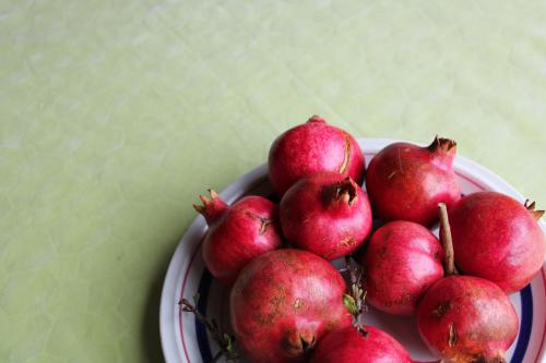 a pile of pomegranates on a plate on a table at Agriturismo Il Caggio in Sovicille