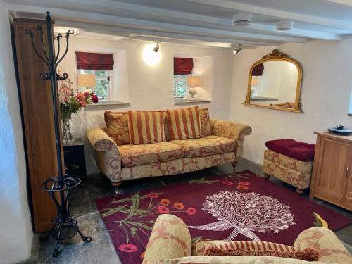 a living room with a couch and a mirror at Chapel Annex in Bodmin