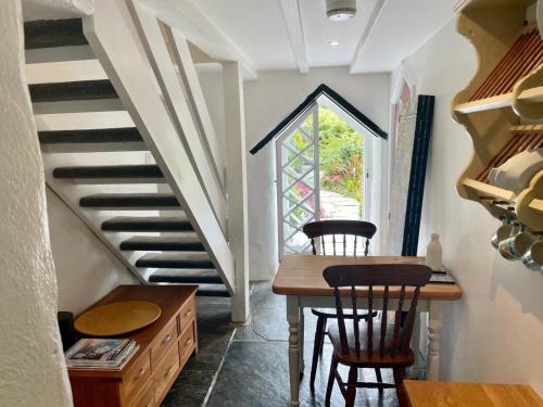a room with a table and chairs and a staircase at Chapel Annex in Bodmin