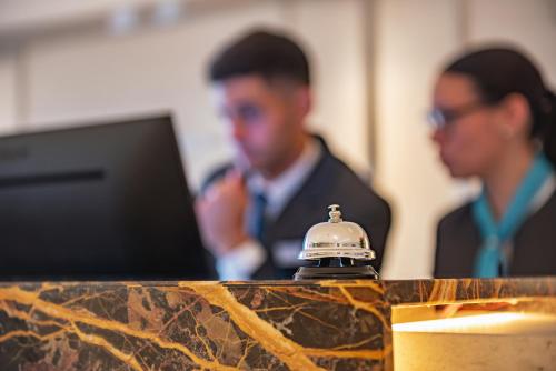 two men standing in front of a laptop computer at HOTEL KONKE MAR DEL PLATA in Mar del Plata